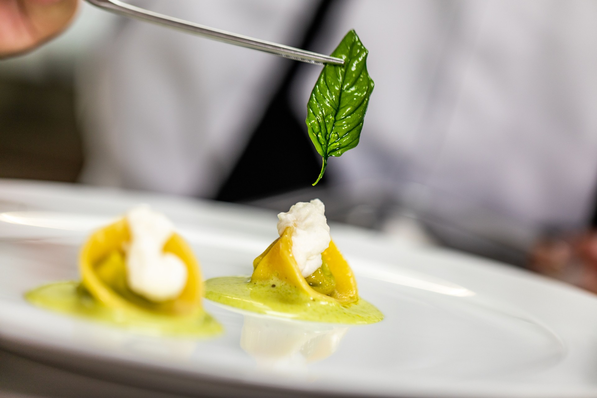 Decorating small bite-sized pasta dish using basil Decorating small bite-sized pasta dish using basil